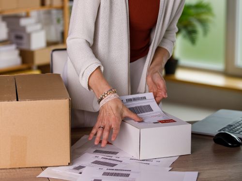 Woman putting a shipping label on a box