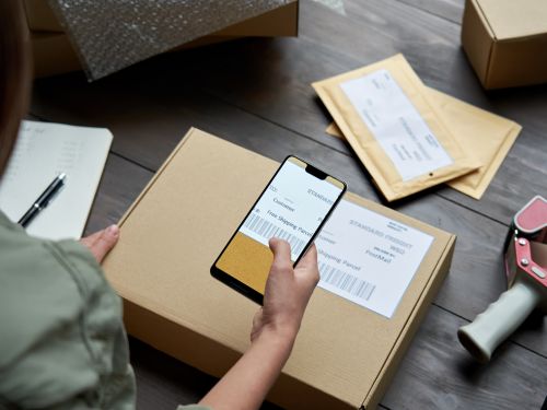 Person scanning a shipping label on a box